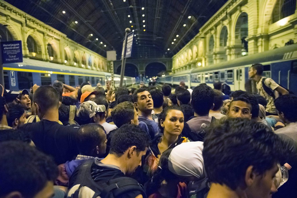 Migrants wait to board a train to German. Foto: DPA