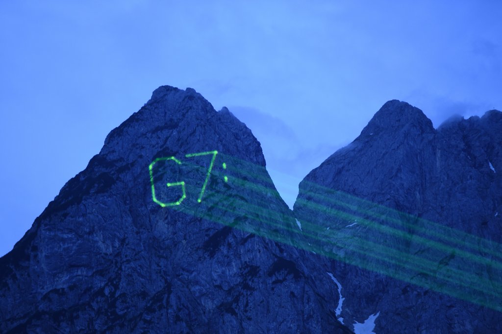 Aktivisten der Umweltschutzorganisation Greenpeace projizieren am 08.06.2015 bei Garmisch-Partenkirchen (Bayern) auf den Waxenstein im Zugspitzmassiv "G7". Foto: Felix Kästle/dpa